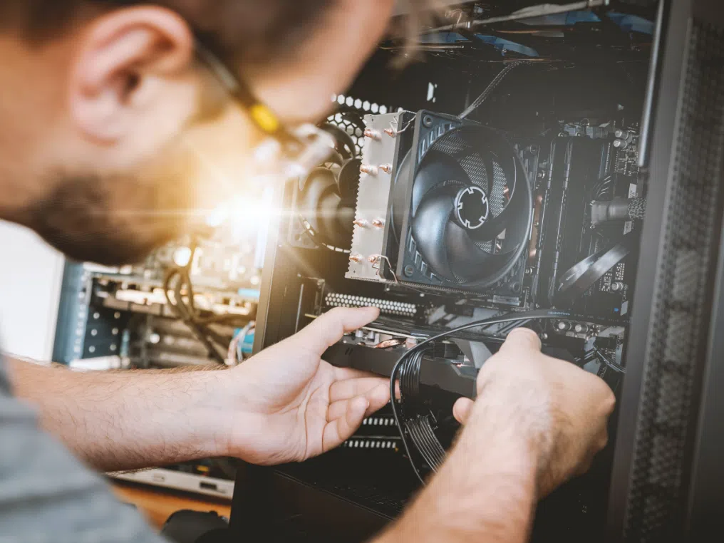 Ein Mann, der in einem Raum an einem Computer arbeitet.