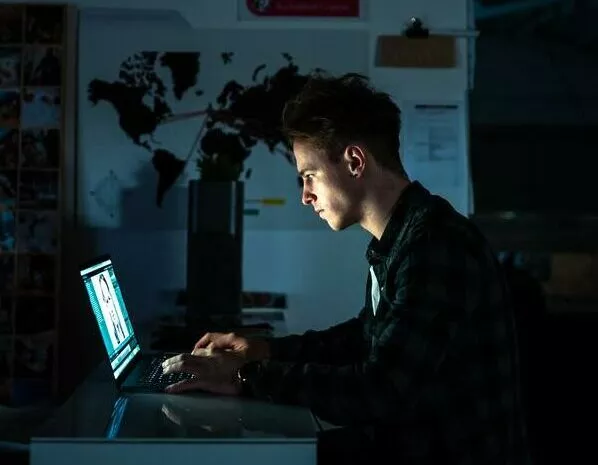 Ein Mann schreibt Prüfungen der AKAD auf einem Laptop an seinem Schreibtisch