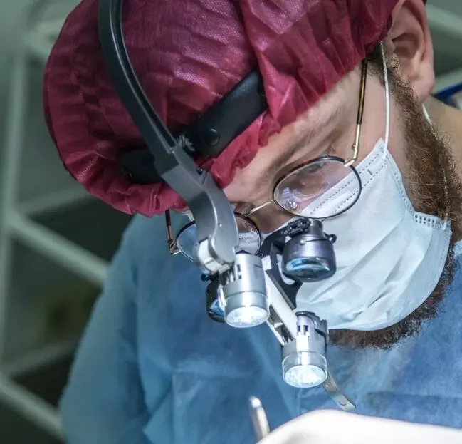 Ein Medizintechniker schaut mit einem Binocular auf einen Gegenstand