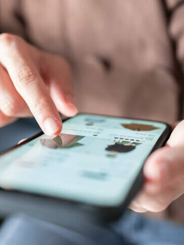 Nahaufnahme einer Person, die auf einem Smartphone tippt