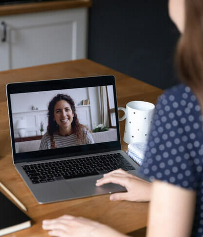 Tutorin erklärt einer Studentin etwas während eines Online-Meetings