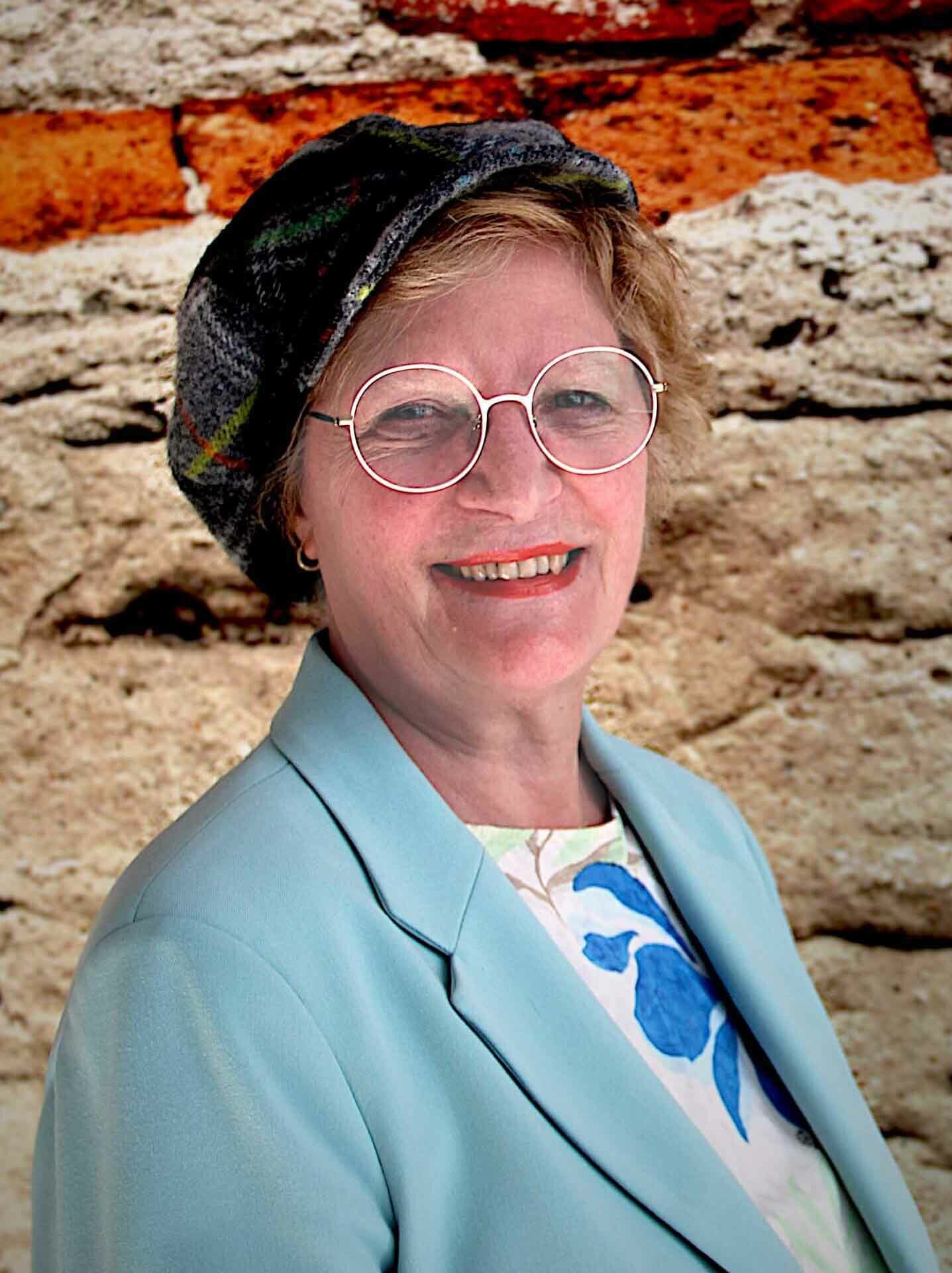 Prof. Dr. Brigitte Souveton-Reichel, stehend im Portrait vor einer Wand