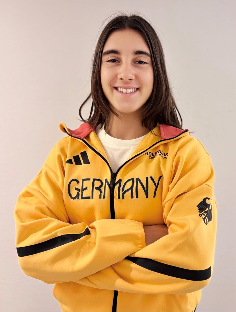 Finja Hermanussen im Deutschland-Trainingsanzug mit verschränkten Armen vor hellem Hintergrund